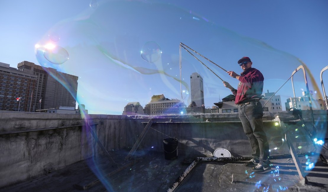 Após acidente, homem refaz a vida como criador de bolhas gigantes e faz sucesso na rua