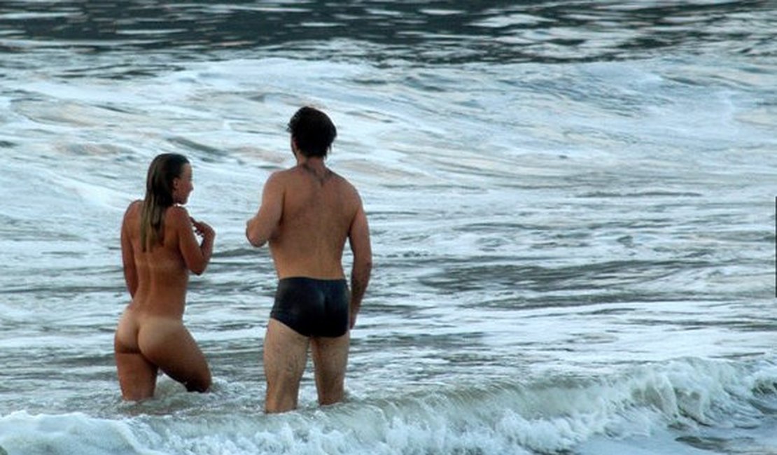 Mulher nua toma banho de mar em praia do Rio 