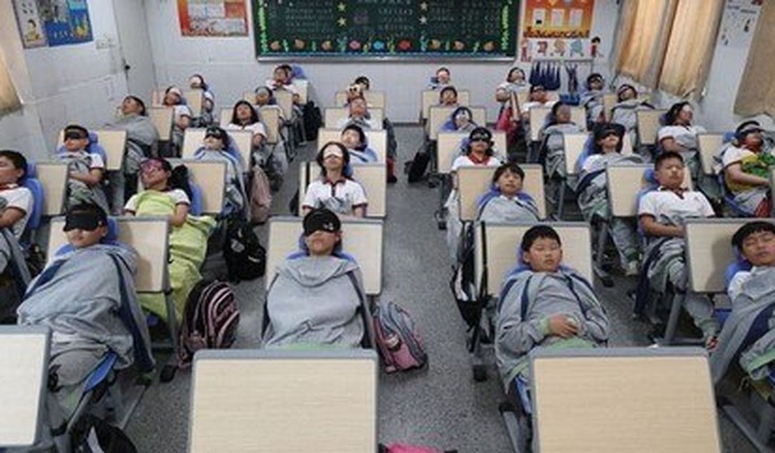 Alunos chineses usam mesas e cadeiras dobráveis para tirar soneca nos intervalos e no almoço