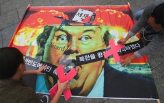 Ativistas anti-guerra finalizam um cartaz com uma caricatura do presidente Donald Trump durante uma manifestação contra ele perto da embaixada dos EUA em Seul, na Coreia do Sul. A mensagem na bandeira diz 'Se a guerra explodir, apenas aqueles na península