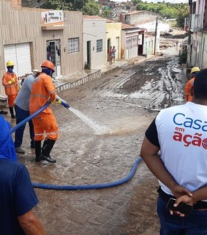 Casal participa de limpeza das ruas atingidas por enchente em Santana do Ipanema
