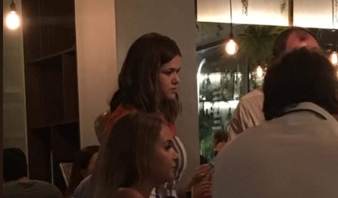 Maísa ajuda garçom em restaurante traduzindo pedidos de clientes