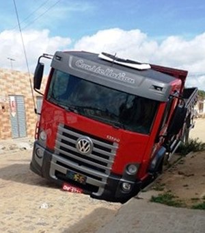 Caminhão fica preso em um buraco aberto no calçamento de rua de Arapiraca