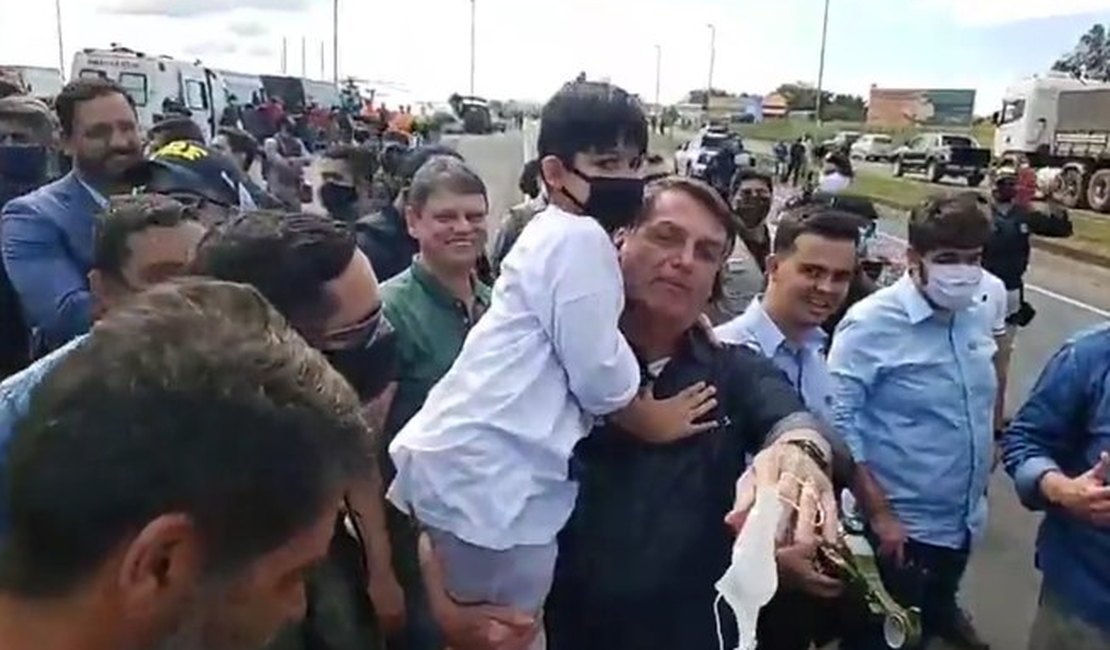 Bolsonaro vai a Minas sem máscara, causa aglomeração e pega criança no colo