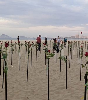 Manifestantes plantam rosas na praia de Copacabana pelas 500 mil vítimas da Covid-19 no Brasil