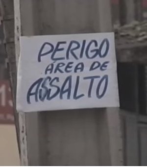 Morador cola cartaz em postes para alertar população sobre assaltos