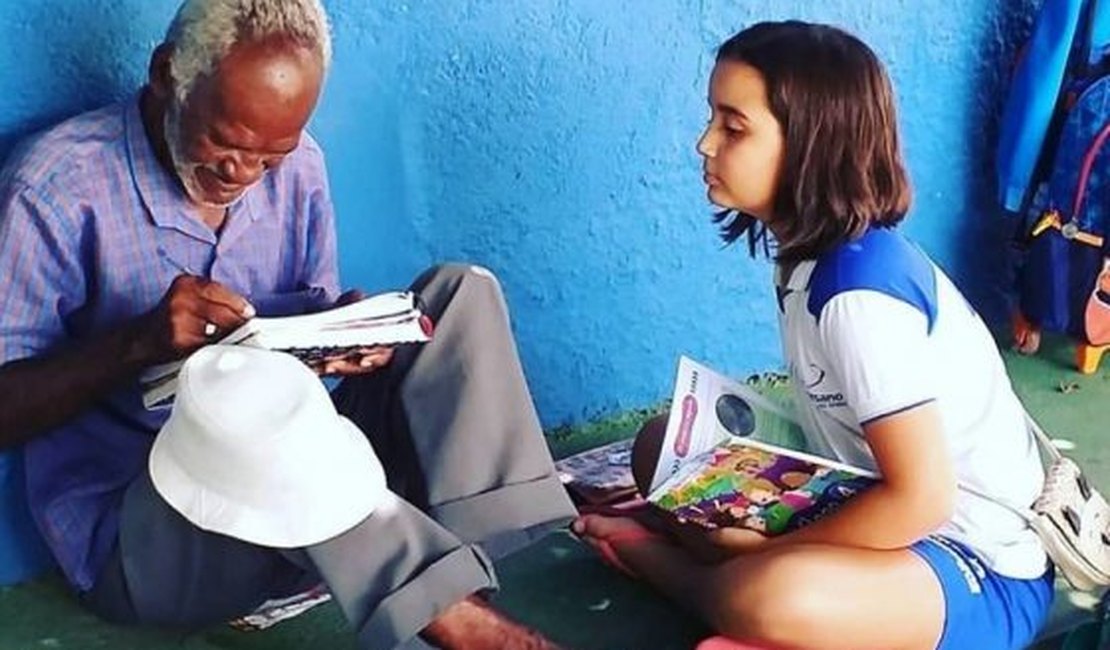 Criança ensina vendedor de picolé a ler e a escrever em chão de pátio da escola