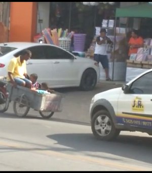 [Vídeo] Homem dirige moto puxando três pessoas num carrinho de mão
