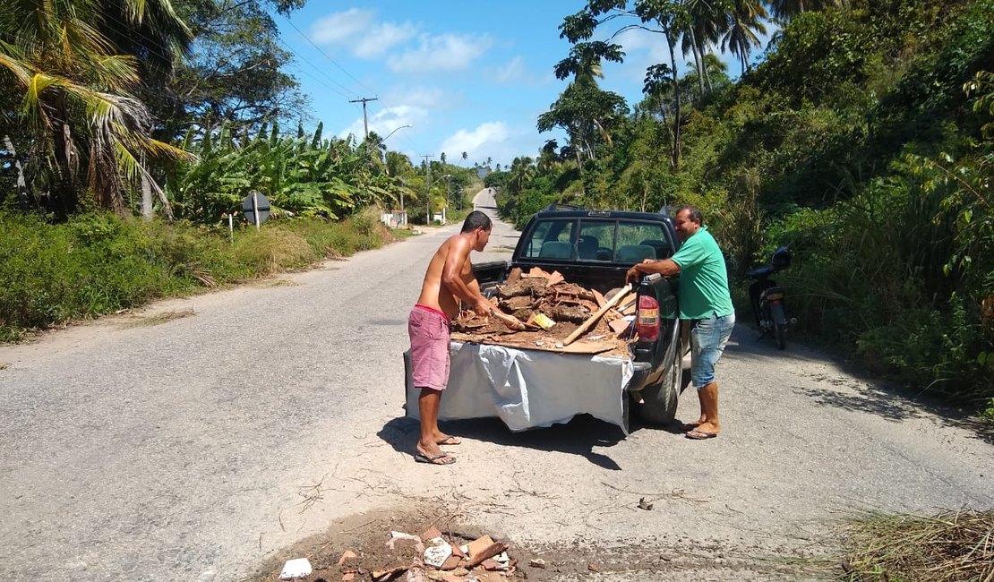 Moradores tapam buracos da rodovia AL 101 Norte com metralhas