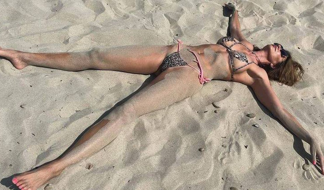 Luciana Gimenez se joga na areia e lamenta fim das férias em Ibiza