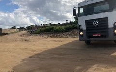 Caminhão baú deixando terreno baldio após descarregar o lixo