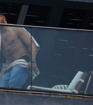 Liam Payne, do One Direction, relaxa na sacada de hotel