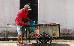 Morador do Cleto carregando baldes de água em carrinho de mão