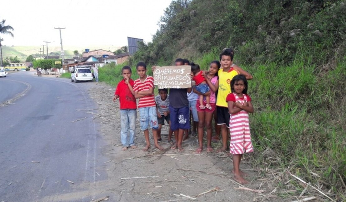 Crianças carentes erguem placa às margens de rodovia para pedir presentes
