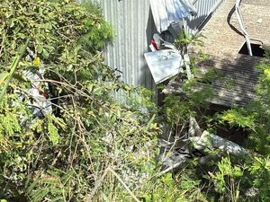 Avião de pequeno porte cai em cima de galpão de oficina e piloto fica preso às ferragens