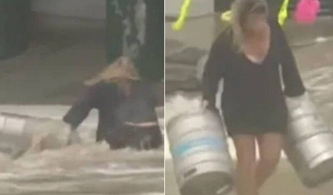 Mulher se arrisca em tempestade e enchente para salvar barris de cerveja