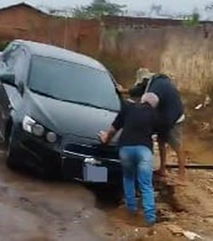 Carro atola em cratera aberta pelas fortes chuvas no bairro Arnon de Mello, em Arapiraca