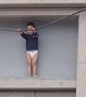 Menino de 3 anos fica preso do lado de fora de prédio a 10 metros de altura na China