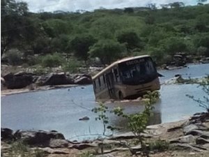 Motorista tenta travessia, mas ônibus escolar fica atolado no meio do rio