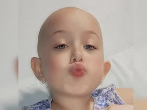 Menina emociona ao voltar à praia após enfrentar tratamento contra leucemia