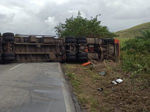 [Vídeo] Carreta tomba, fica atravessada na BR-104 e deixa motorista preso às ferragens