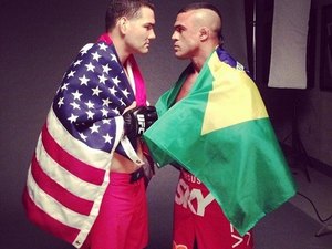 Chris Weidman e Vitor Belfort posam juntos com bandeiras de EUA e Brasil