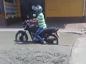 Homem fura bloqueio de obra e fica com moto presa em cimento fresco