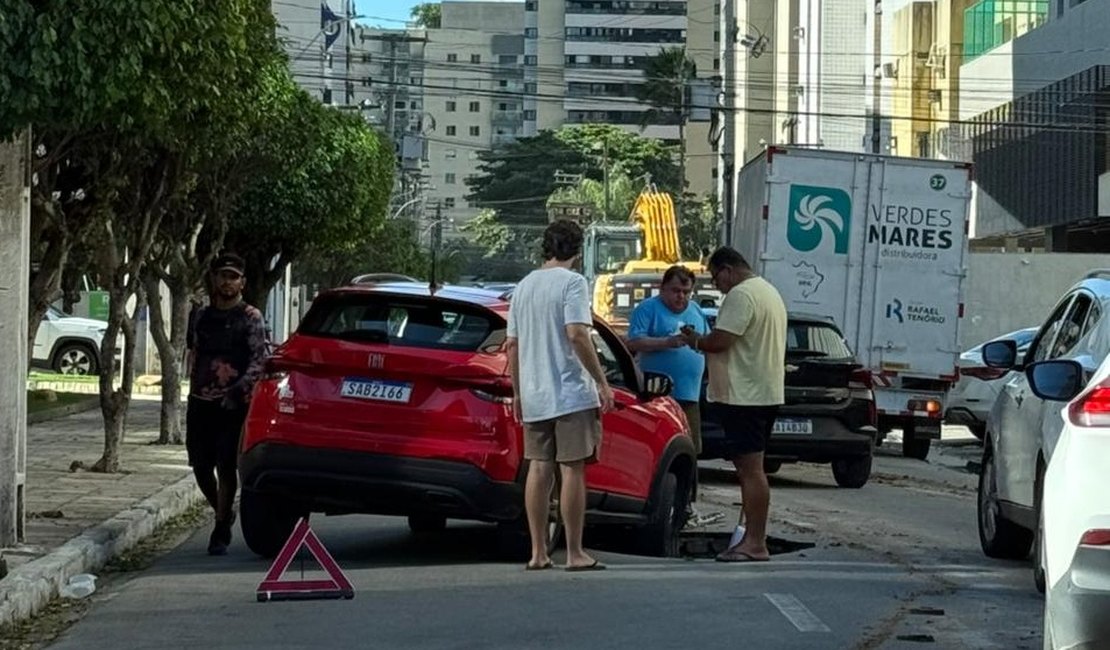 Carro cai em cratera aberta após chuvas no bairro da Ponta Verde, em Maceió