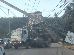 [Vídeo] Caminhão entrelaça caçamba em fios e derruba três postes AL 101 Norte