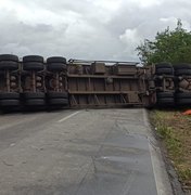 [Vídeo] Carreta tomba, fica atravessada na BR-104 e deixa motorista preso às ferragens