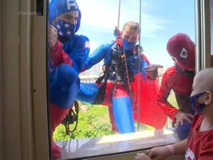 Super-heróis descem de rapel pelas paredes de hospital e fazem surpresa para crianças em tratamento contra o câncer