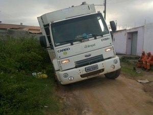 Caminhão de lixo atola ao passar por rua sem pavimentação