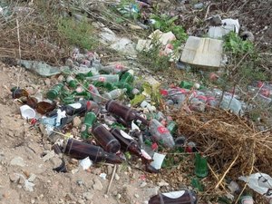 Comerciante joga garrafas de vidro em terreno