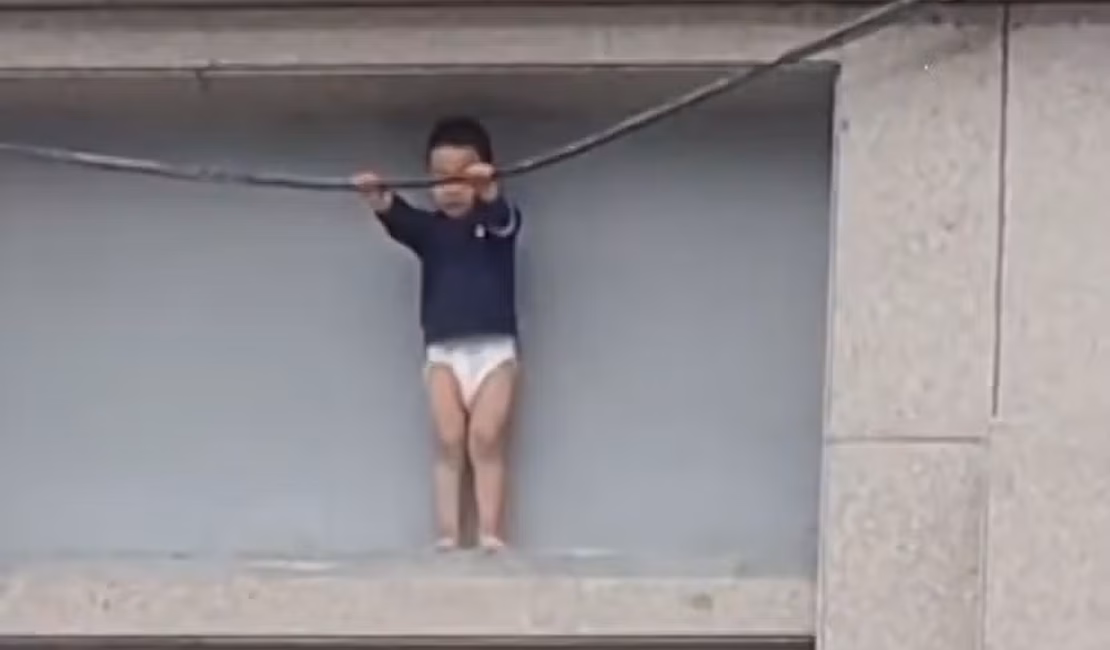 Menino de 3 anos fica preso do lado de fora de prédio a 10 metros de altura na China