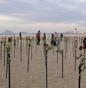 Manifestantes plantam rosas na praia de Copacabana pelas 500 mil vítimas da Covid-19 no Brasil