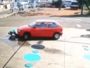 Carro passa por cima de frentista que estava agachado em posto de combustível