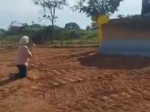 Idosa se ajoelha para tentar impedir máquina de entrar em fazenda para obra de duplicação da GO-330