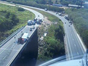 Carreta carregada com pneus tomba e tem carga saqueada por populares no Pilar