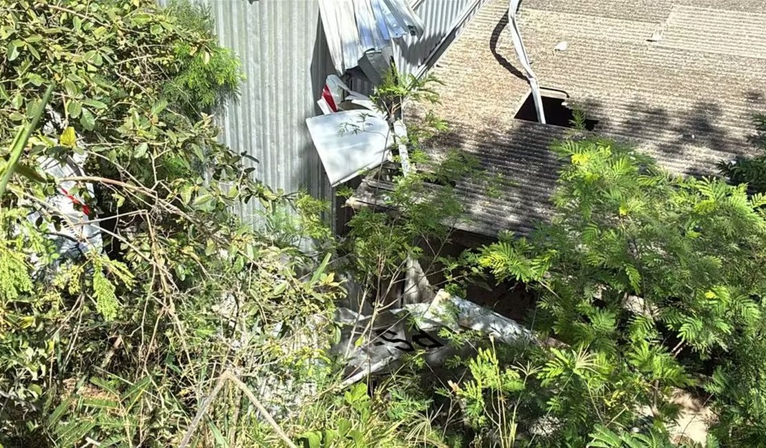 Avião de pequeno porte cai em cima de galpão de oficina e piloto fica preso às ferragens