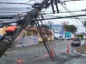 Caminhão se enrosca com fios elétricos, puxa poste e rua fica interditada no Farol