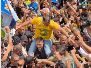 Flávio Bolsonaro refaz cena do atentado contra o pai durante ato