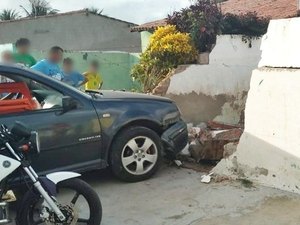 Mulher perde o controle de carro e bate em muro de residência