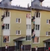 Russos escalam prédio e salvam 3 crianças de incêndio com 'cordão humano'