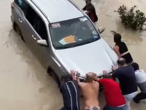 Cícero Cavalcante tenta passar por via inundada e carro precisa ser empurrado por Fernando Cavalcante e populares