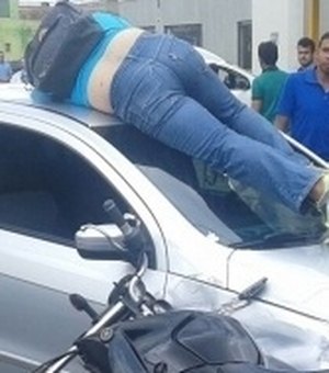 Após colisão entre carro e moto, motociclista fica em cima de automóvel