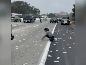 Porta de blindado se abre e estrada nos EUA fica coberta por dinheiro