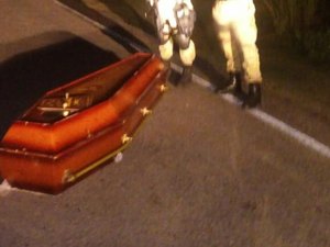 Caixão cai de carro funerário e corpo fica abandonado em estrada 