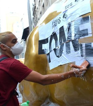Escultura do “touro de ouro” amanhece pichada e com cartaz contra a fome
