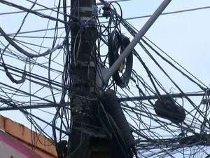 Além de poluir a paisagem, emaranhado de fios em postes de energia geram riscos à população