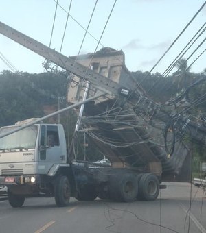 [Vídeo] Caminhão entrelaça caçamba em fios e derruba três postes AL 101 Norte